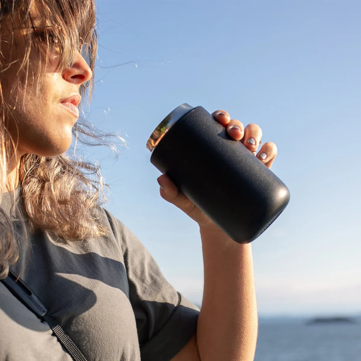 Drinking from a matte black Carter Move mug outdoors