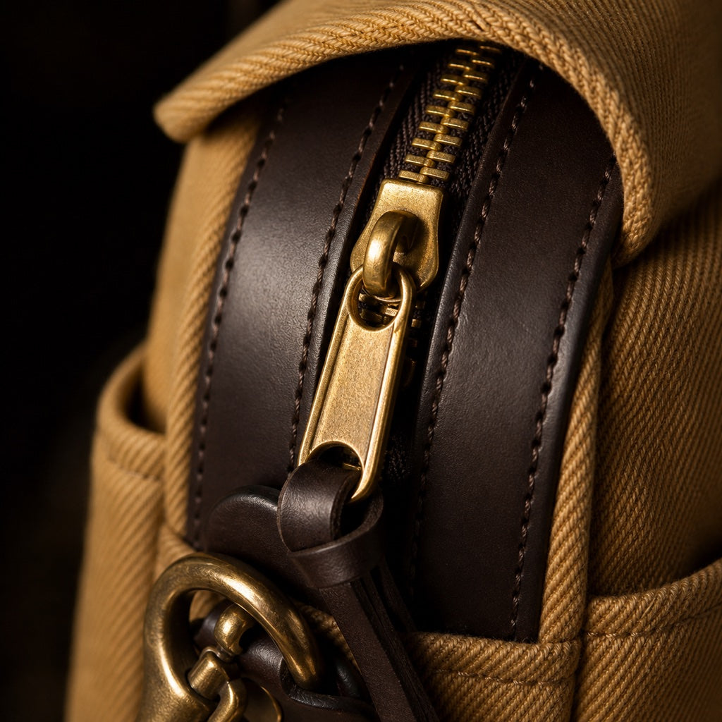 Macro of solid brass zipper against dark bridle leather