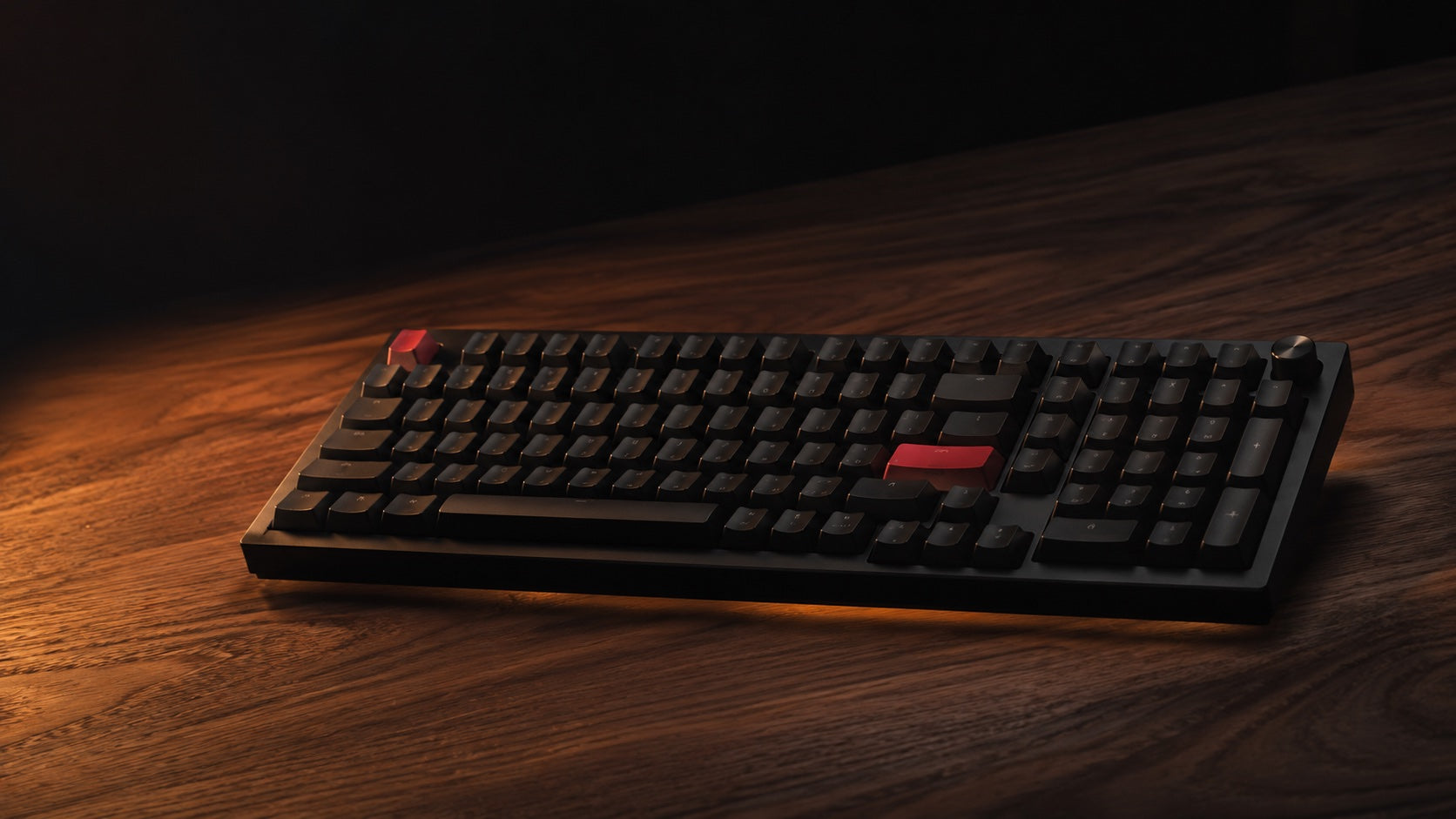 The Keychron Q5 Max full-aluminum keyboard on a dark walnut desk under a warm tungsten lamp.