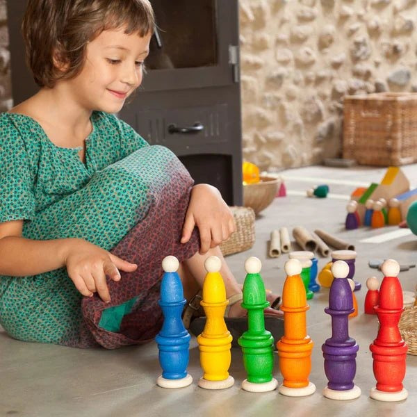 Child playing with Grapat colorful Nins mates stacked on coins