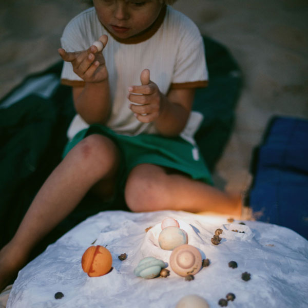 Child playing with Grapat Dear Universe wooden planets