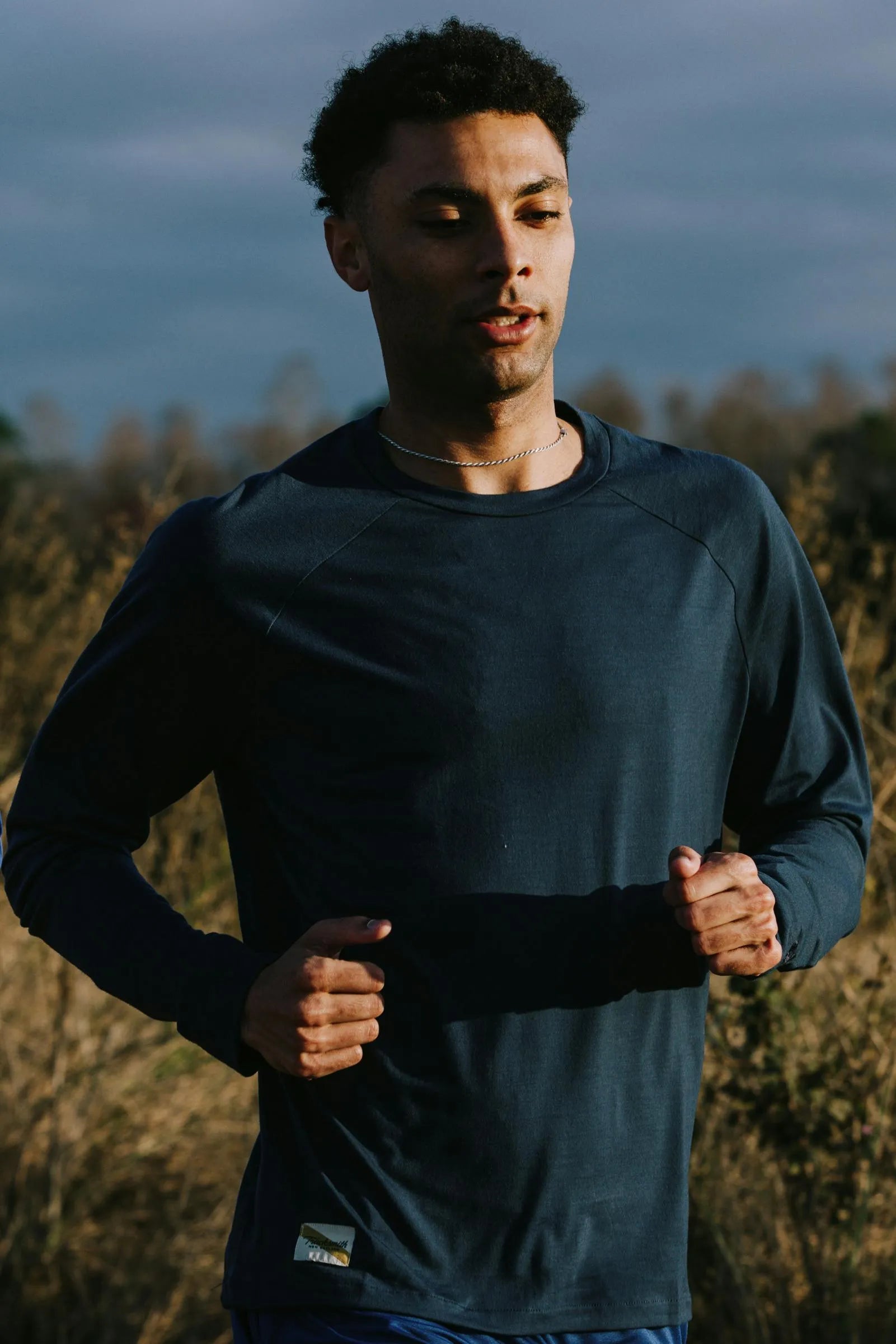 Runner in the navy Harrier Long Sleeve mid-stride