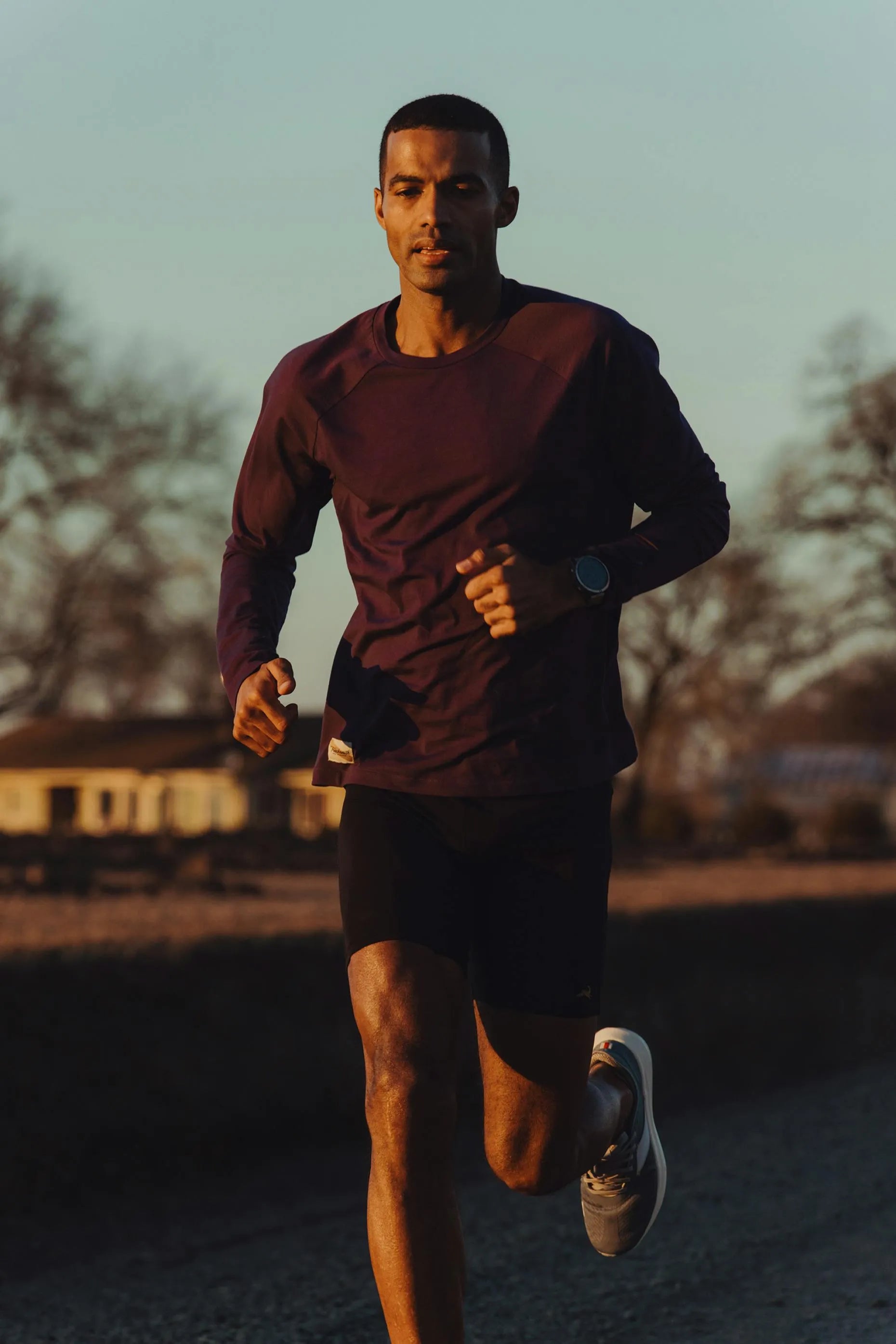 A runner silhouetted on a road at golden hour