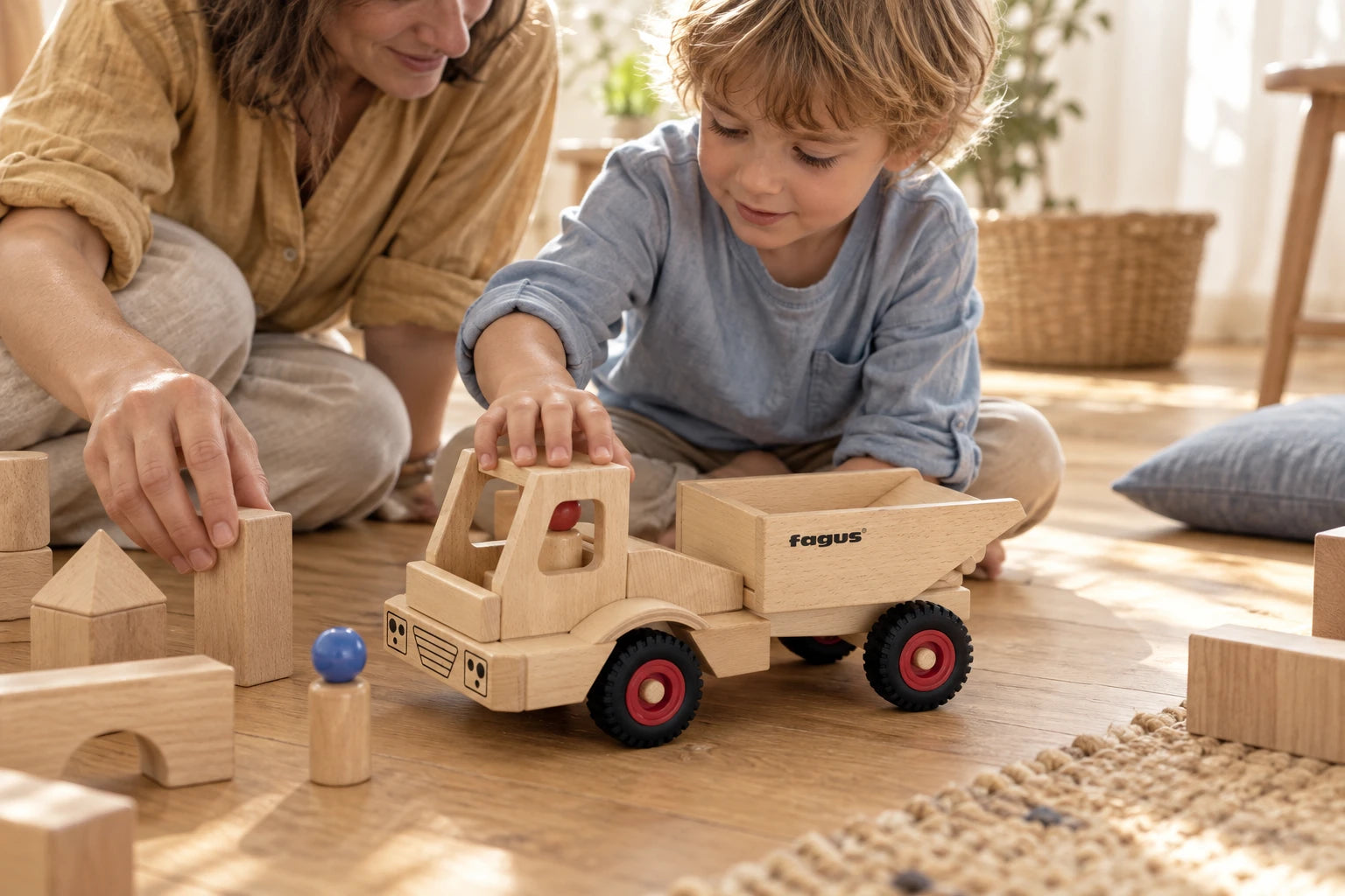 A child and parent making a little wooden world around a Fagus dump truck