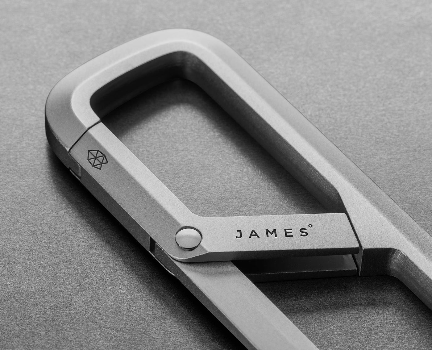 Macro view of The Madison satin titanium finish, pivot and faceted JAMES gate