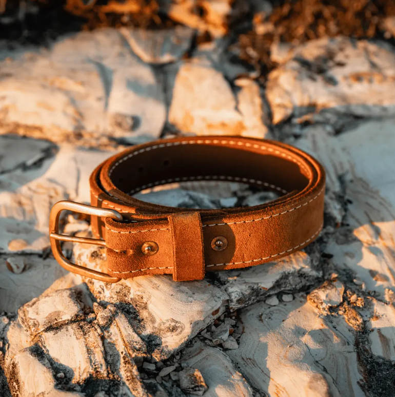 Brown roughout belt and brass buckle in warm outdoor light