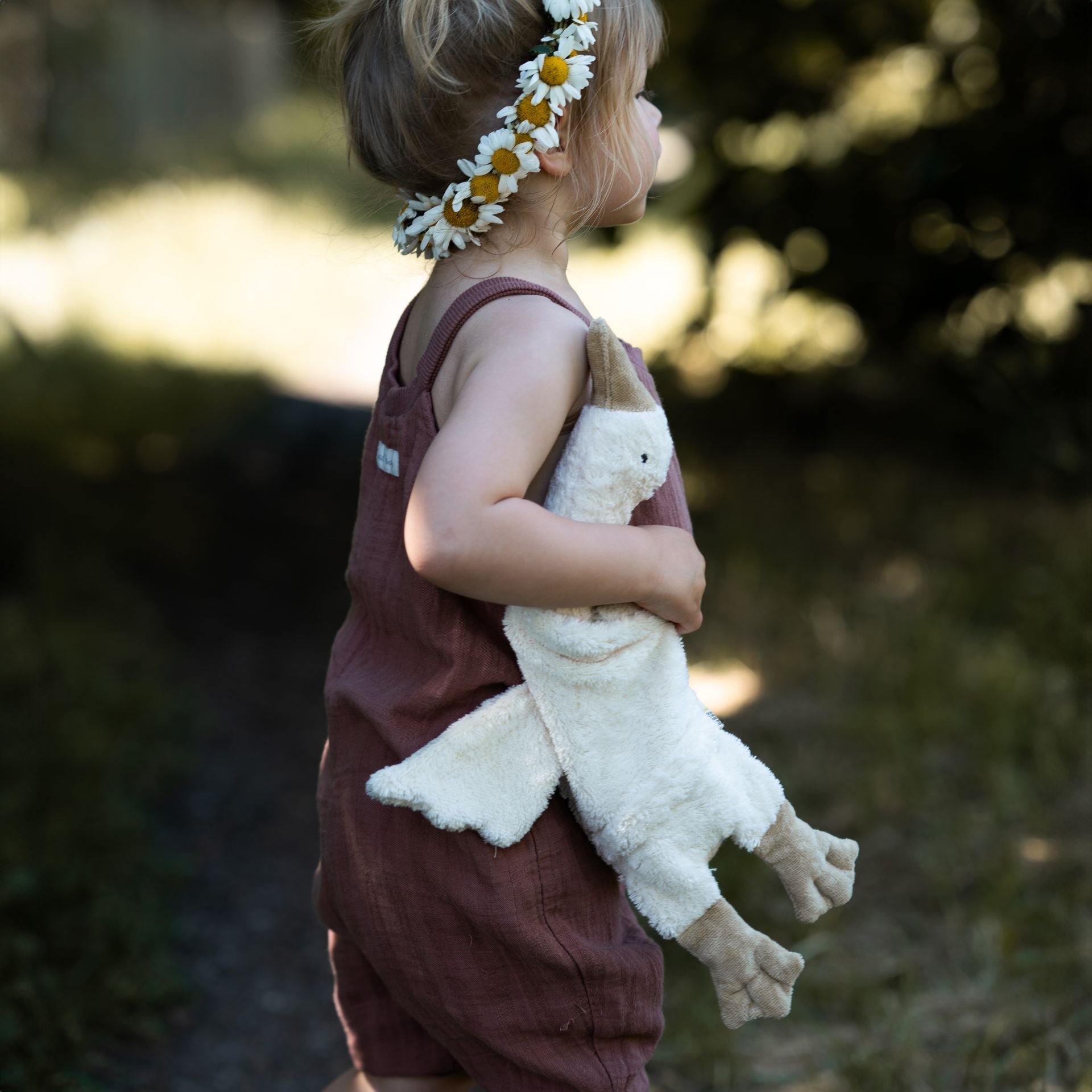 A child holding a white Senger goose outdoors